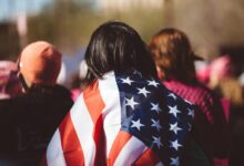 woman with US American flag on her shoulders