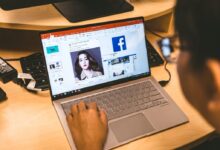person using laptop browsing facebook application