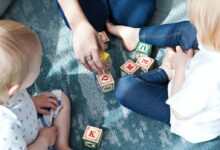 two toddler playing letter cubes