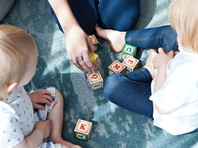 two toddler playing letter cubes