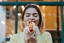 woman in white crew neck t-shirt eating apple