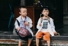 2 boys sitting on brown wooden bench