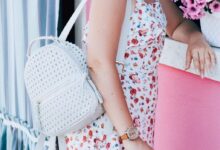 woman wearing floral dress and holding backpack