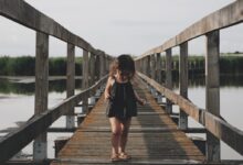 girl wearing black camisole walking on dock