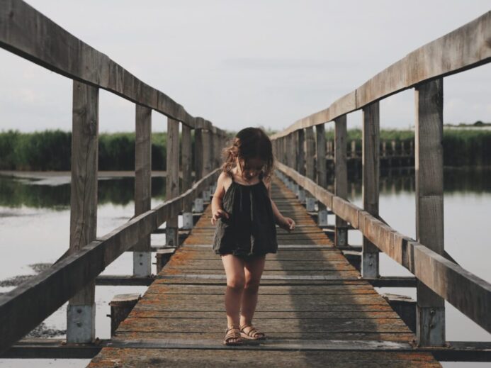 girl wearing black camisole walking on dock