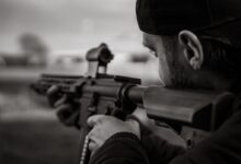 man in black knit cap holding rifle
