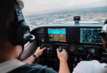 man flying aircraft under cloudy sky