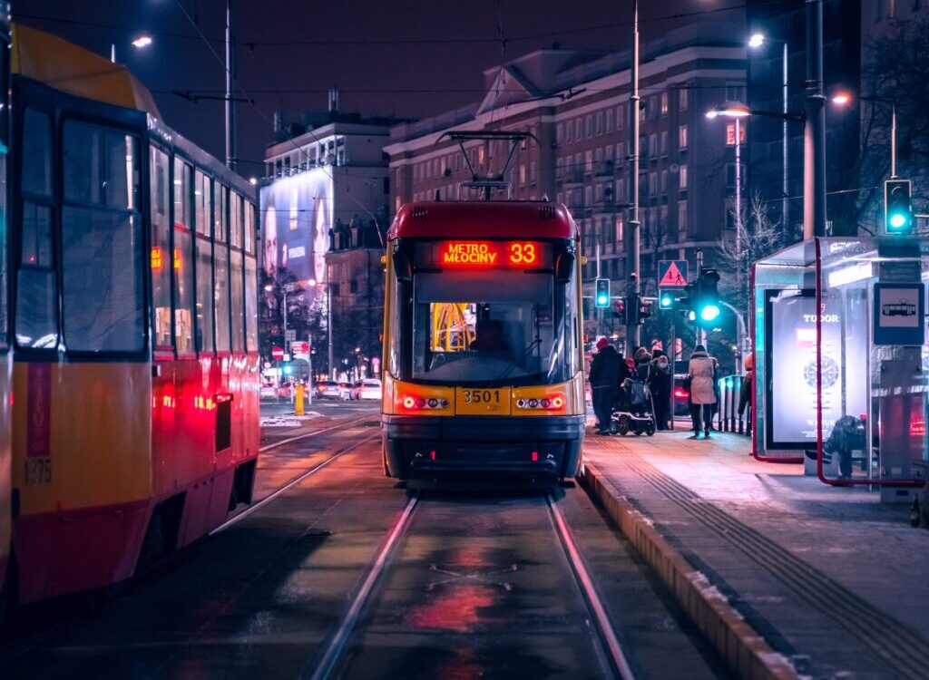 red and black tram on road during night time
