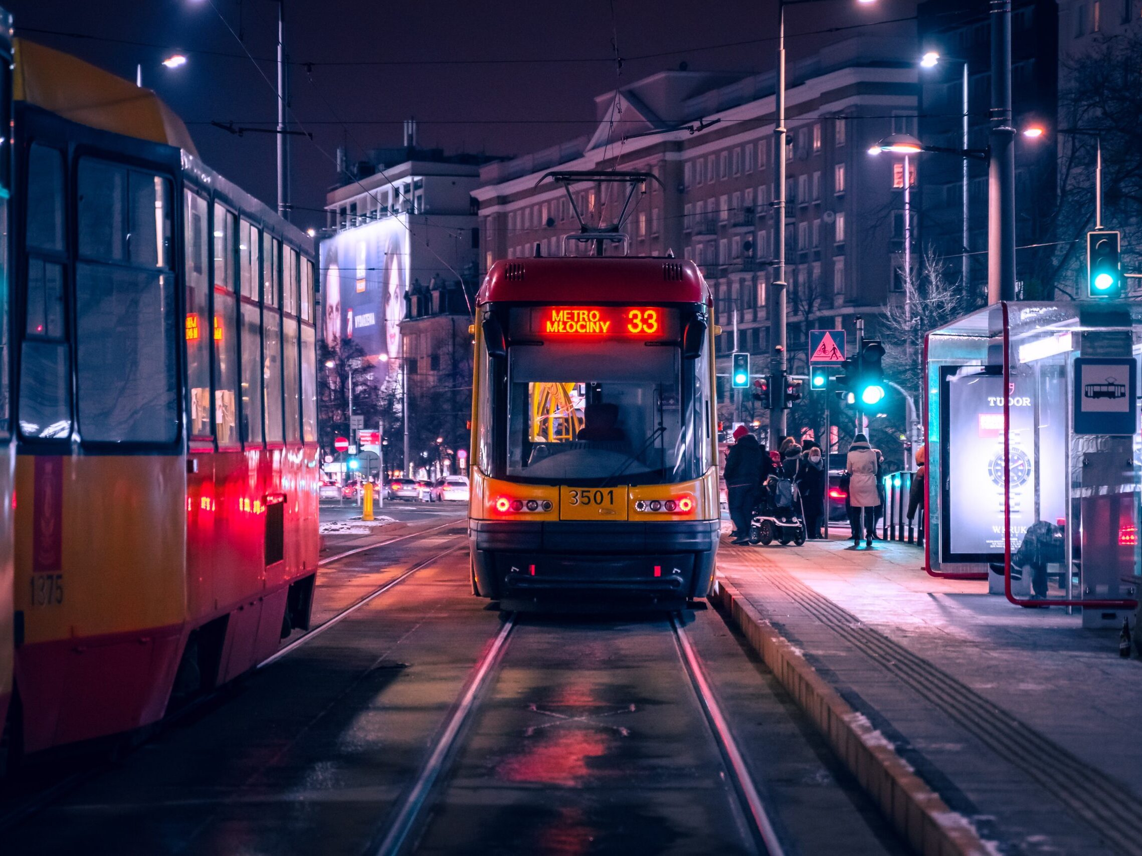 red and black tram on road during night time