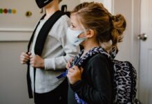 woman in black long sleeve shirt holding white face mask