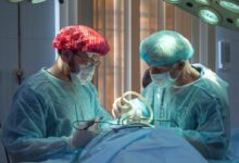 two men wearing blue lab coats
