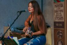 woman playing guitar while singing