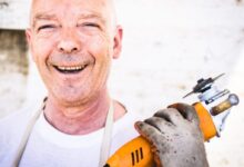 man holding orange angle grinder
