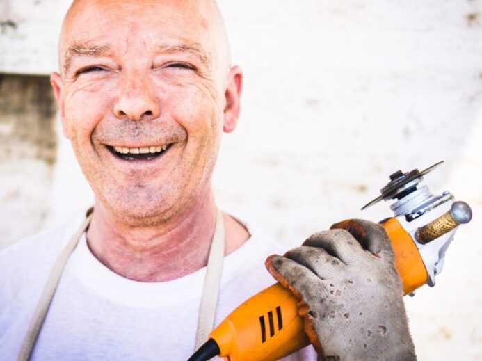 man holding orange angle grinder