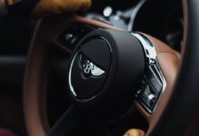 person holding black and silver nissan steering wheel