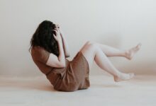 woman sitting on floor wearing brown dress