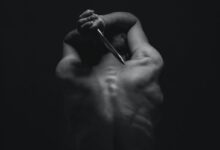 man holding gray dagger