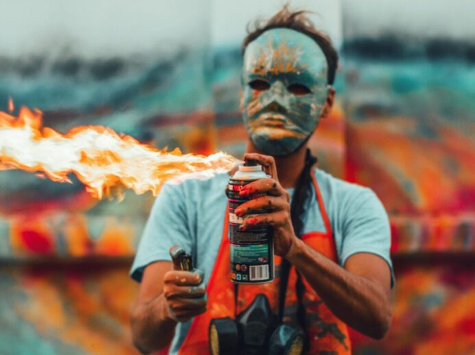 man in white crew neck t-shirt holding black and orange bottle