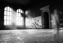 grayscale photo of person standing inside building