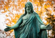 statue of a woman with a background of trees