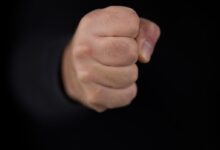 persons fist on black background