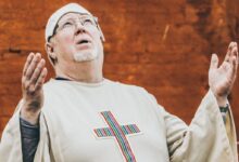 priest standing near brown concrete wall