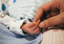 person holding baby's index finger