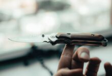 person holding silver and brown pocket knife