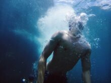 man swimming under water