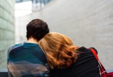 a woman rests her head on another person's shoulder