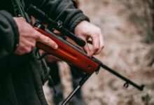 person loading brown and black sniper rifle