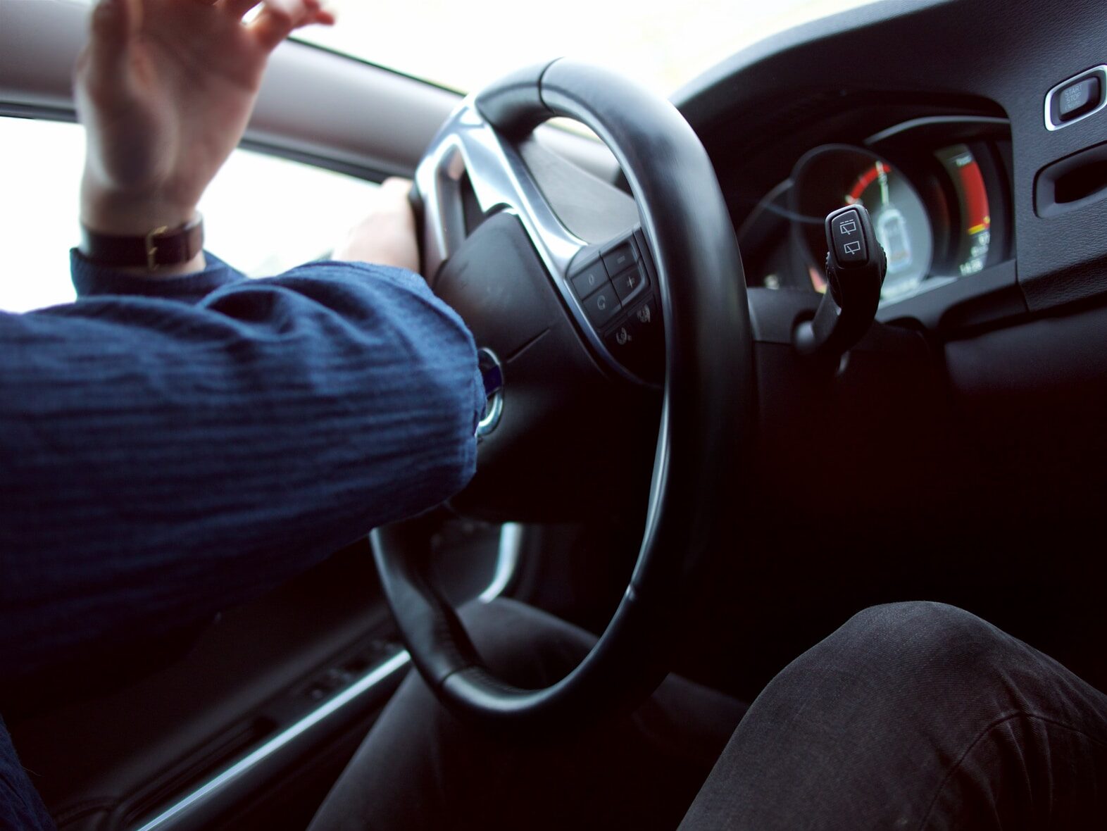man holding black steering wheel