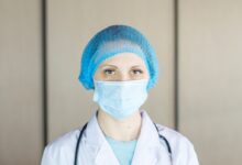 person wearing blue knit cap and white face mask