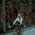 woman in white long sleeve shirt riding on black bicycle on road during daytime