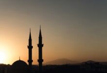 two mosque minarets under calm sky