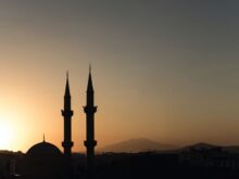 two mosque minarets under calm sky