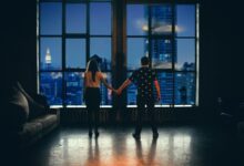 man and woman holding hands in front of glass window