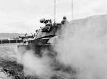 grayscale photo of soldiers on battle tank