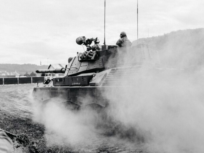 grayscale photo of soldiers on battle tank