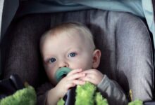 baby on gray stroller