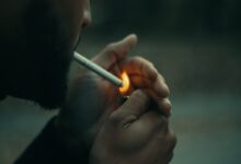 close-up photography of man using cigarette during daytime