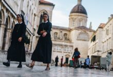 two nun walking in front of cathedral