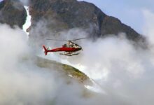 Red Helicopter on Top of Foggy Mountain