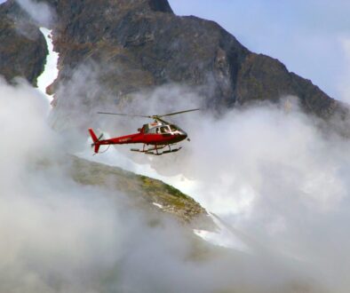 Red Helicopter on Top of Foggy Mountain
