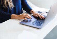woman in blue long sleeve shirt using macbook pro