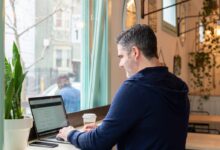 man in blue long sleeve shirt using macbook pro