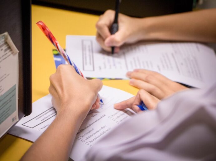 person writing on white paper