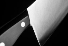 grayscale photo of gray cleaver with black handle