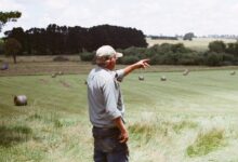 man wearing gray long-sleeved shirt on green grass field