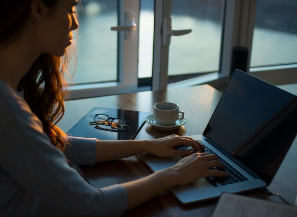 woman sitting beside table using laptop